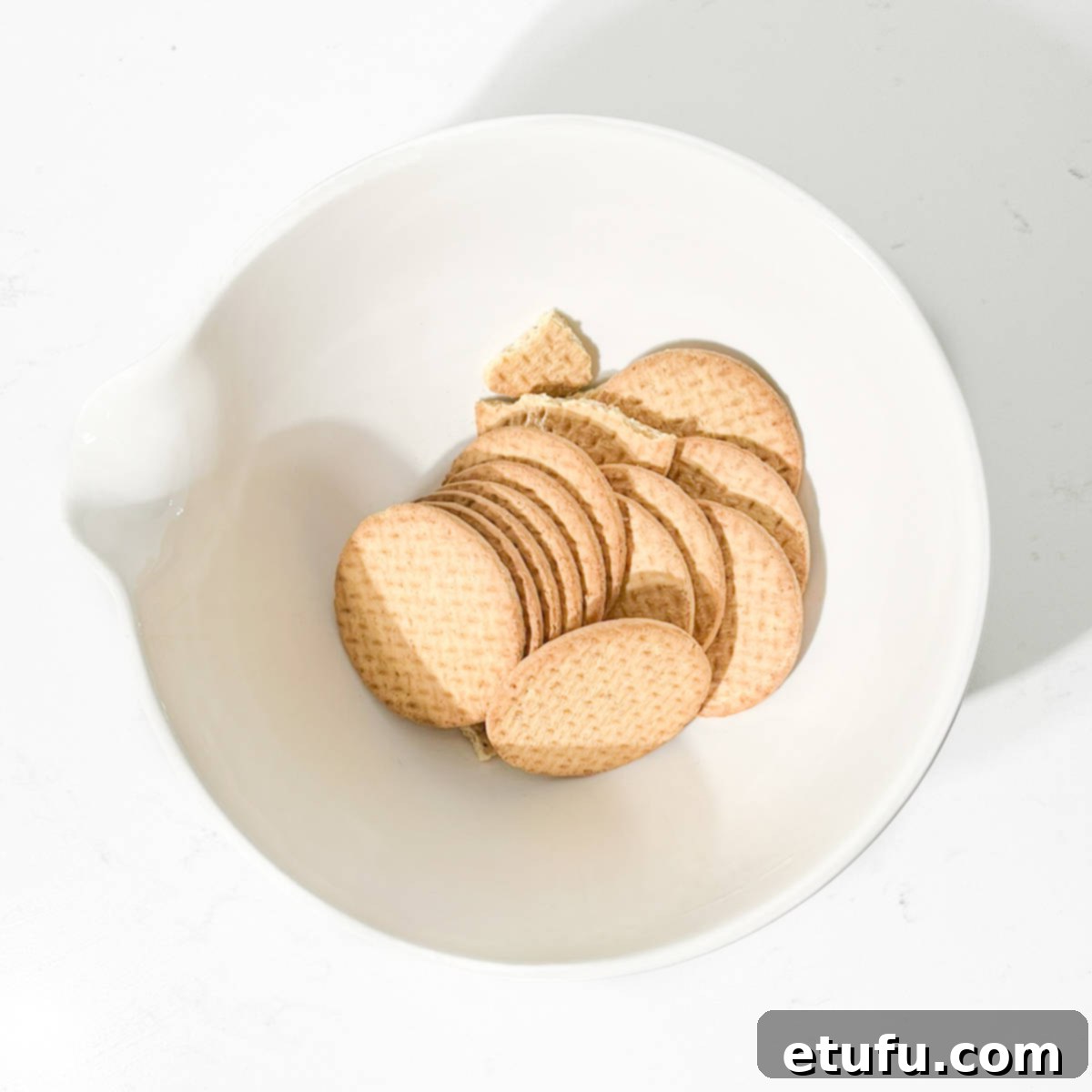 Effortless Date Bars 12 A pile of whole digestive biscuits in a large white bowl.