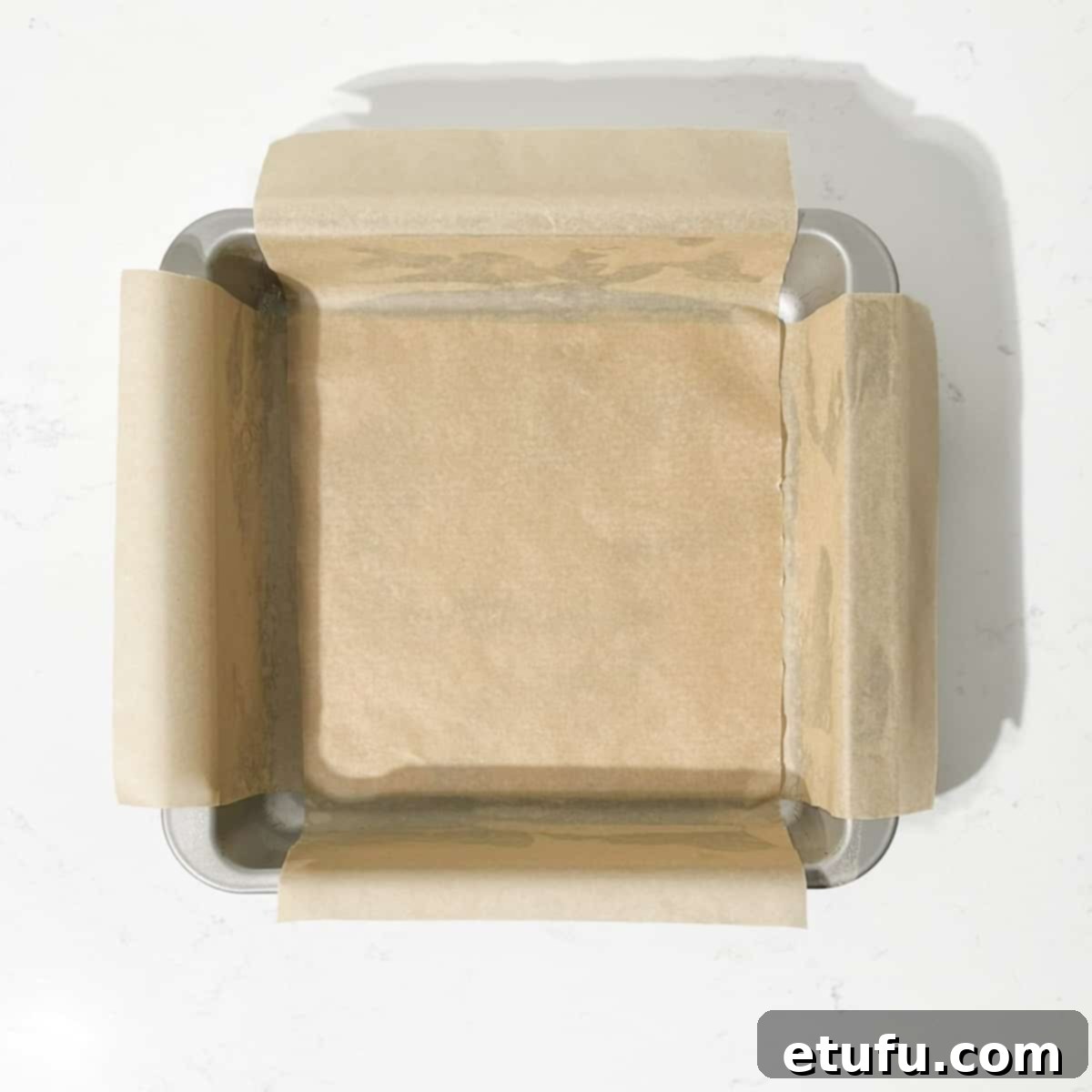 Effortless Date Bars 4 A square tin lined with baking paper, showing the overhang for easy removal.