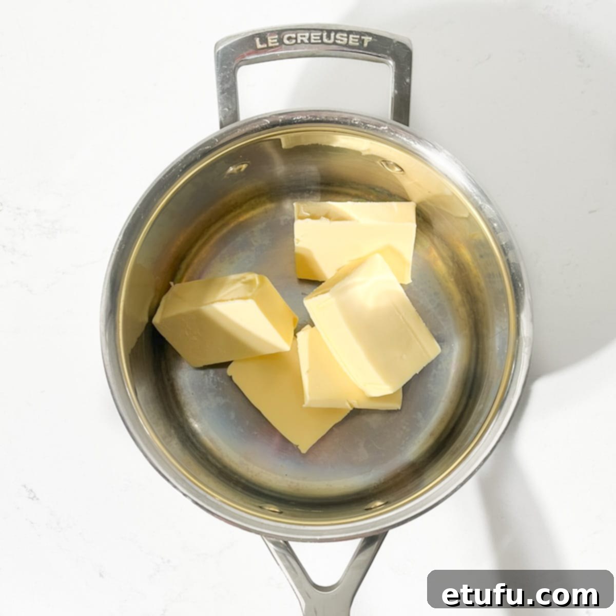 Effortless Date Bars 5 Adding cubes of butter to a saucepan on the stove.