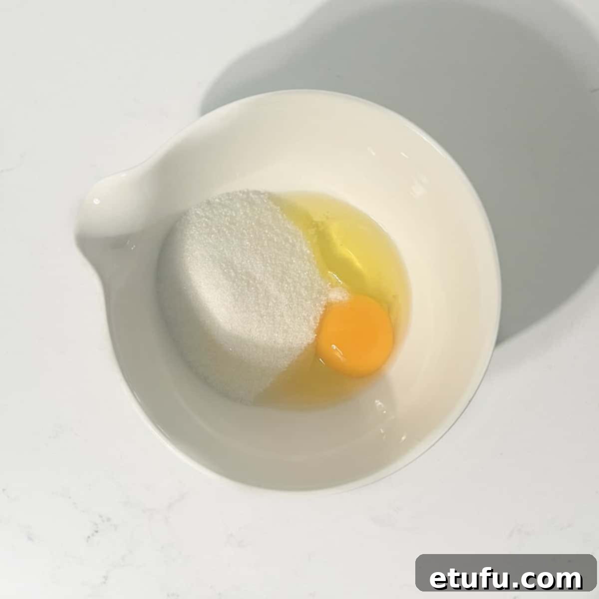 Effortless Date Bars 8 An egg, sugar, and a pinch of salt in a small bowl, ready to be whisked.