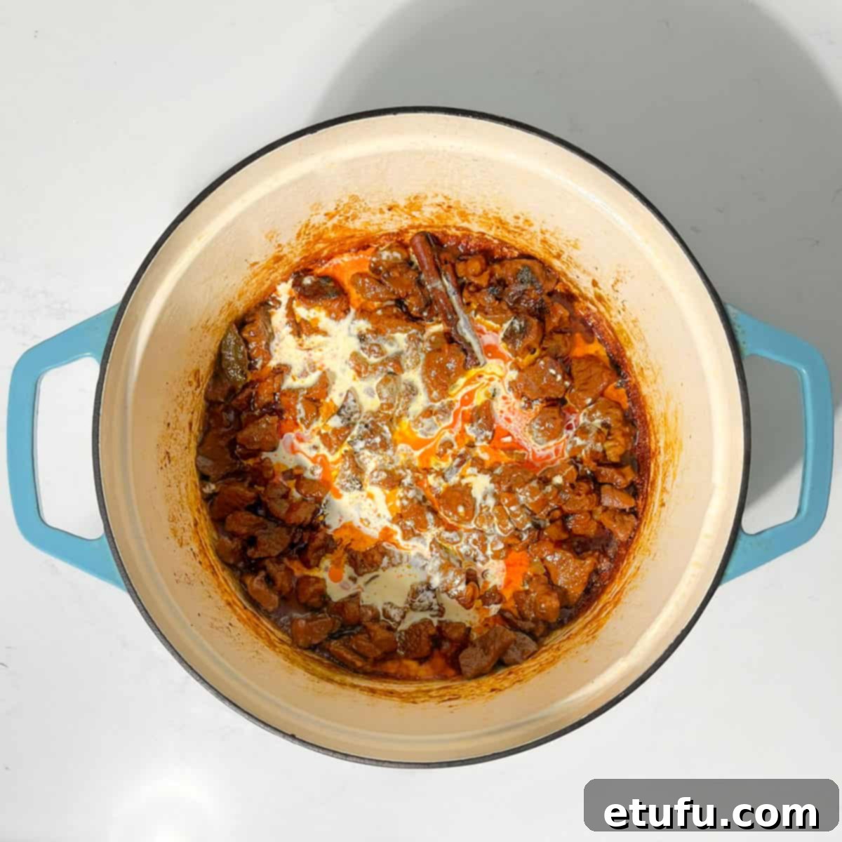 Adding cream to the beef coconut curry.
