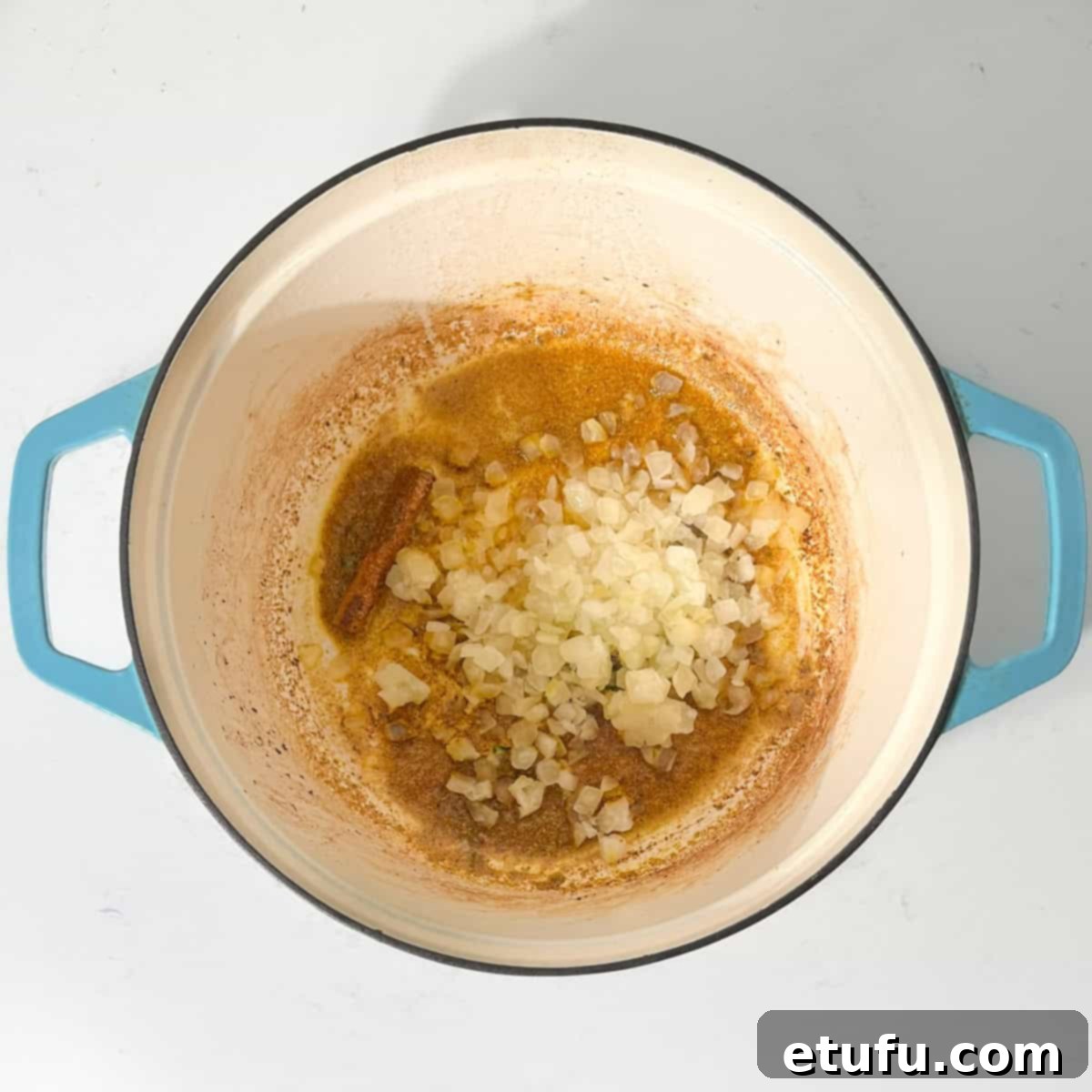 Adding onions to the hot oil for the beef curry with coconut milk.