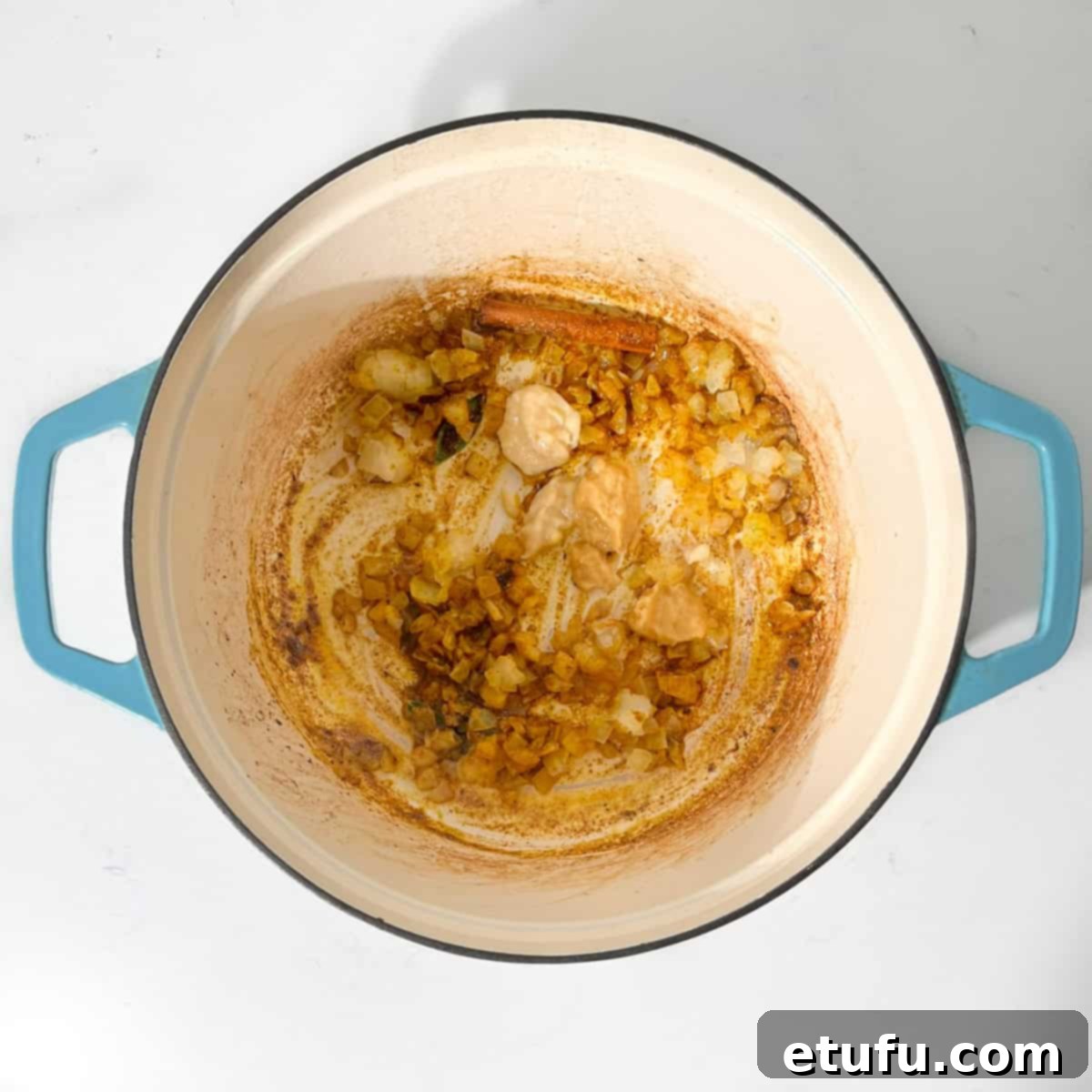 Adding garlic and ginger to the fried onions in a large saucepan.