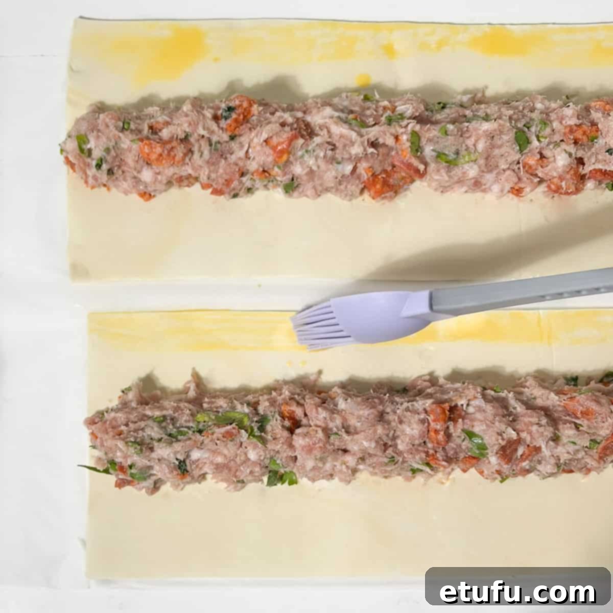 Brushing the eff wash onto the pastry.