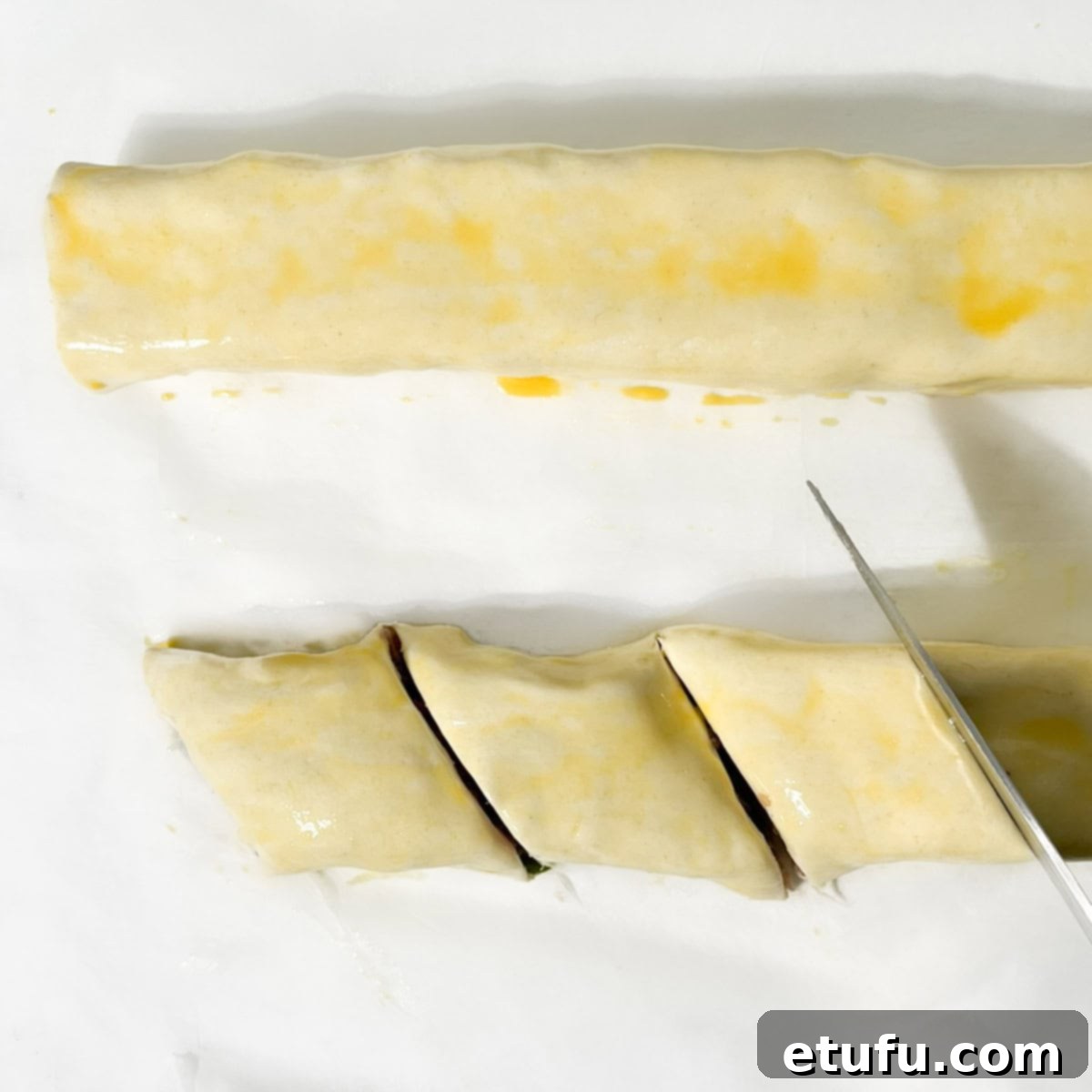 Slicing the sausage rolls into mini sausage rolls.