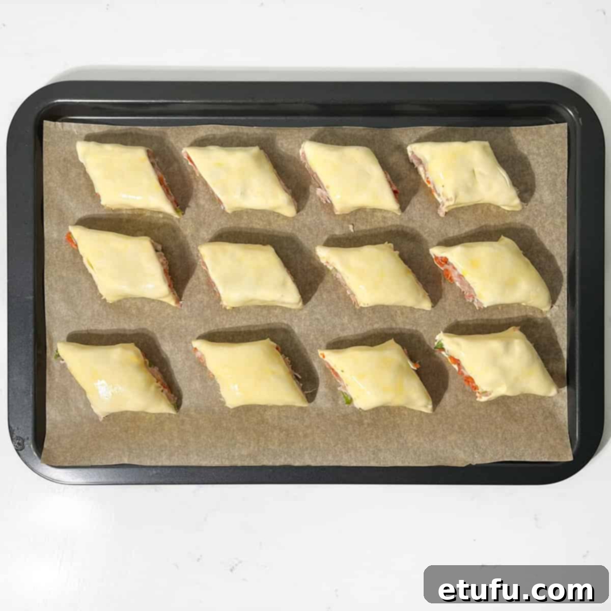 Sausage rolls on a baking sheet.