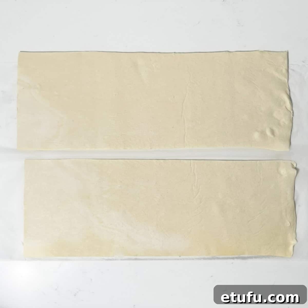 Cutting the puff pastry in half lengthways for the mini sausage rolls.