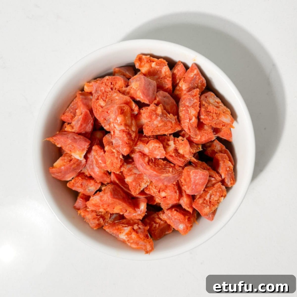 Diced chorizo for the mini sausage rolls in a small white bowl.