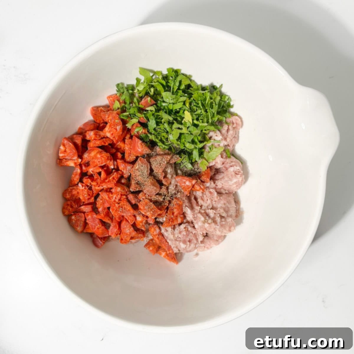 All the ingredients for the mini sausage rolls in a large white bowl.