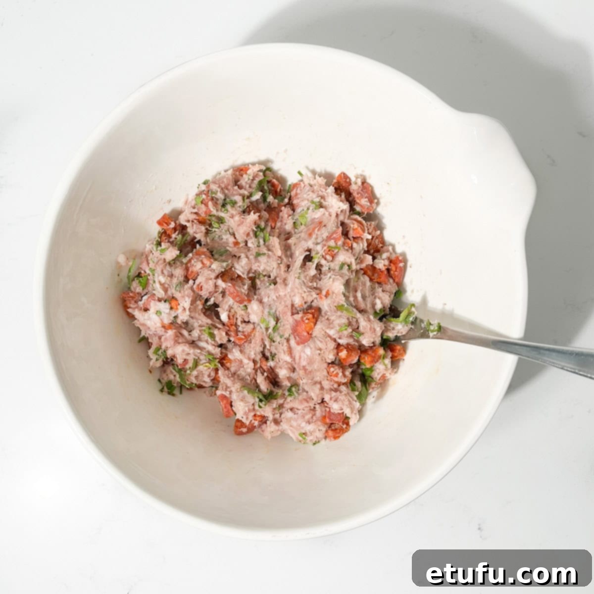 Mini sausage roll filling in a large white bowl.