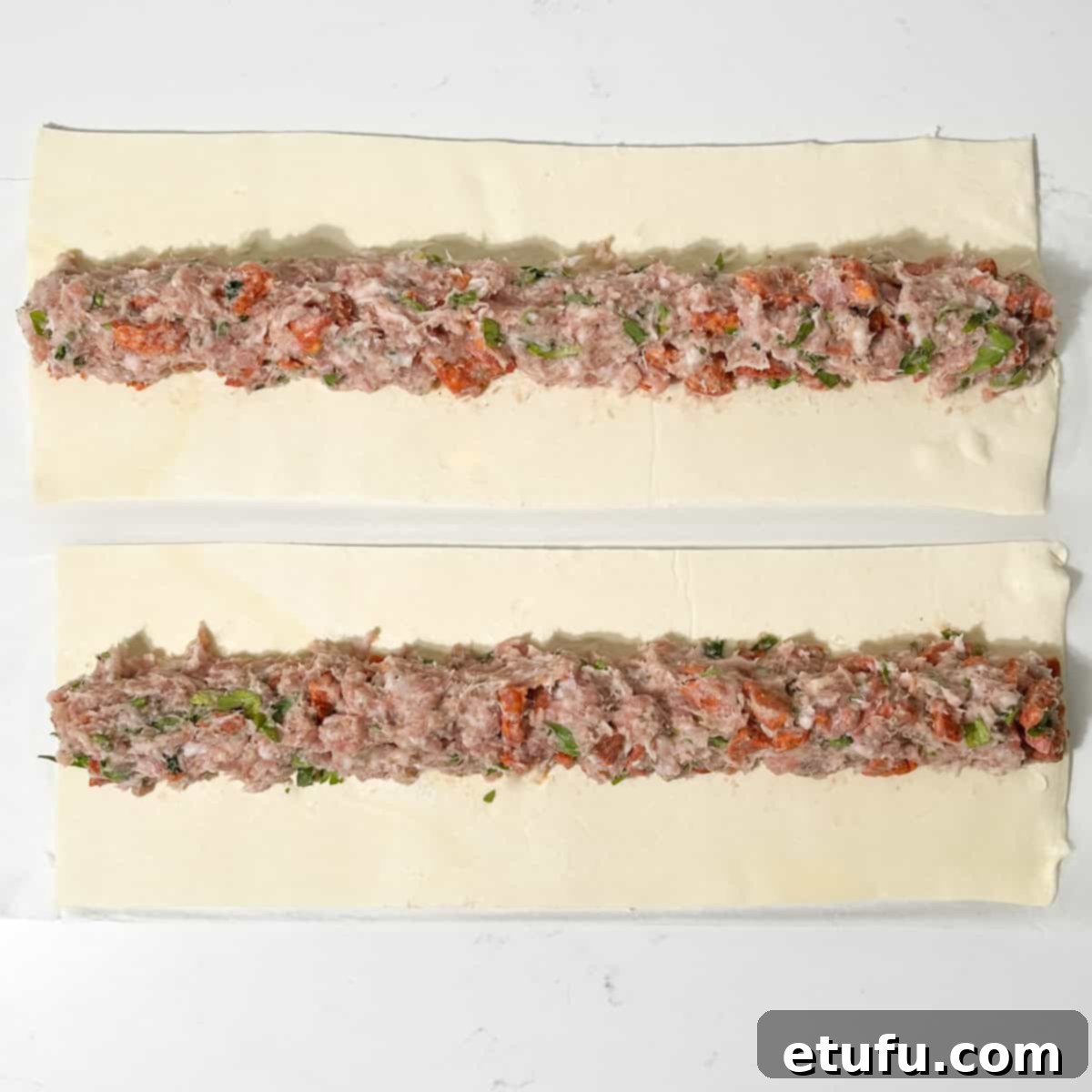 Shaping the sausage roll filling onto the puff pastry strips.