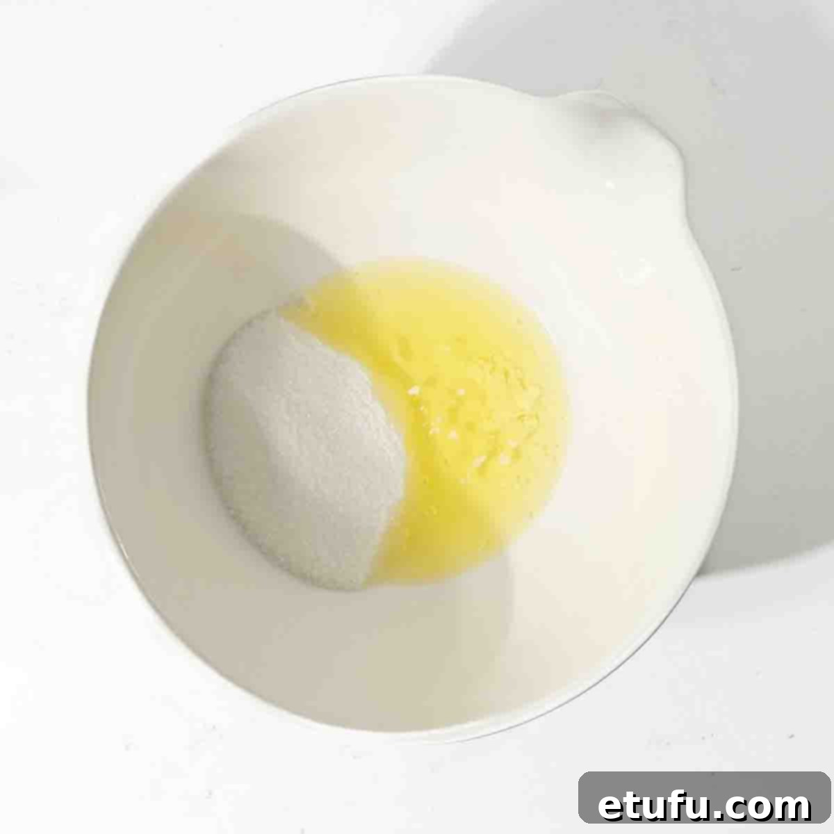 Eggs, sugar, and cream of tartar measured into a clean white mixing bowl, ready to be heated.