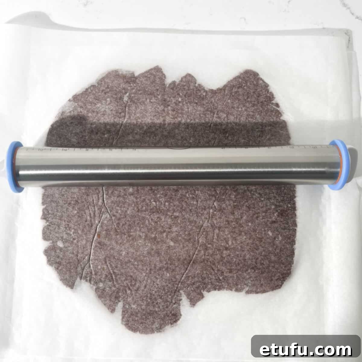 Rolling out the chocolate shortbread dough with a rolling pin.