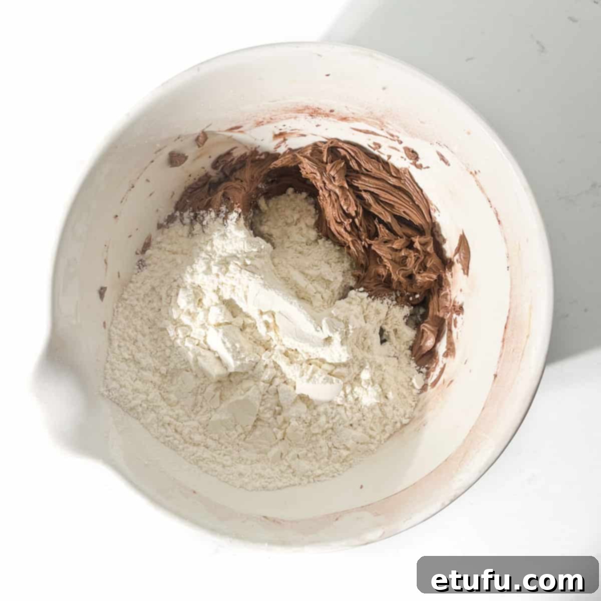 Adding dry flour to the butter and sugar mixture.