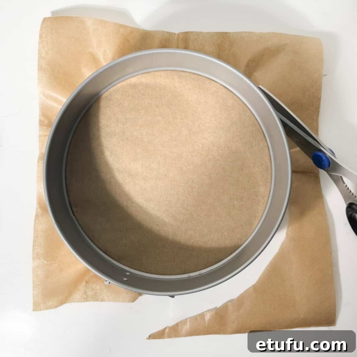 Lining an 8 inch springform tin with baking paper for the cheesecake base.