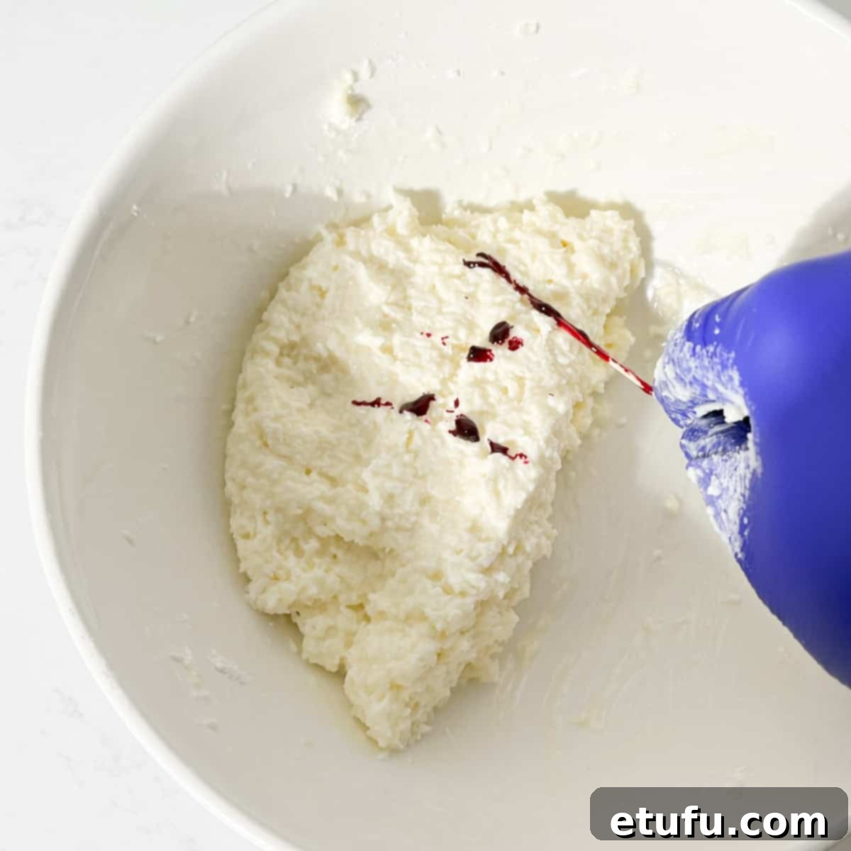 Adding food colouring to one half of the coconut ice mixture.