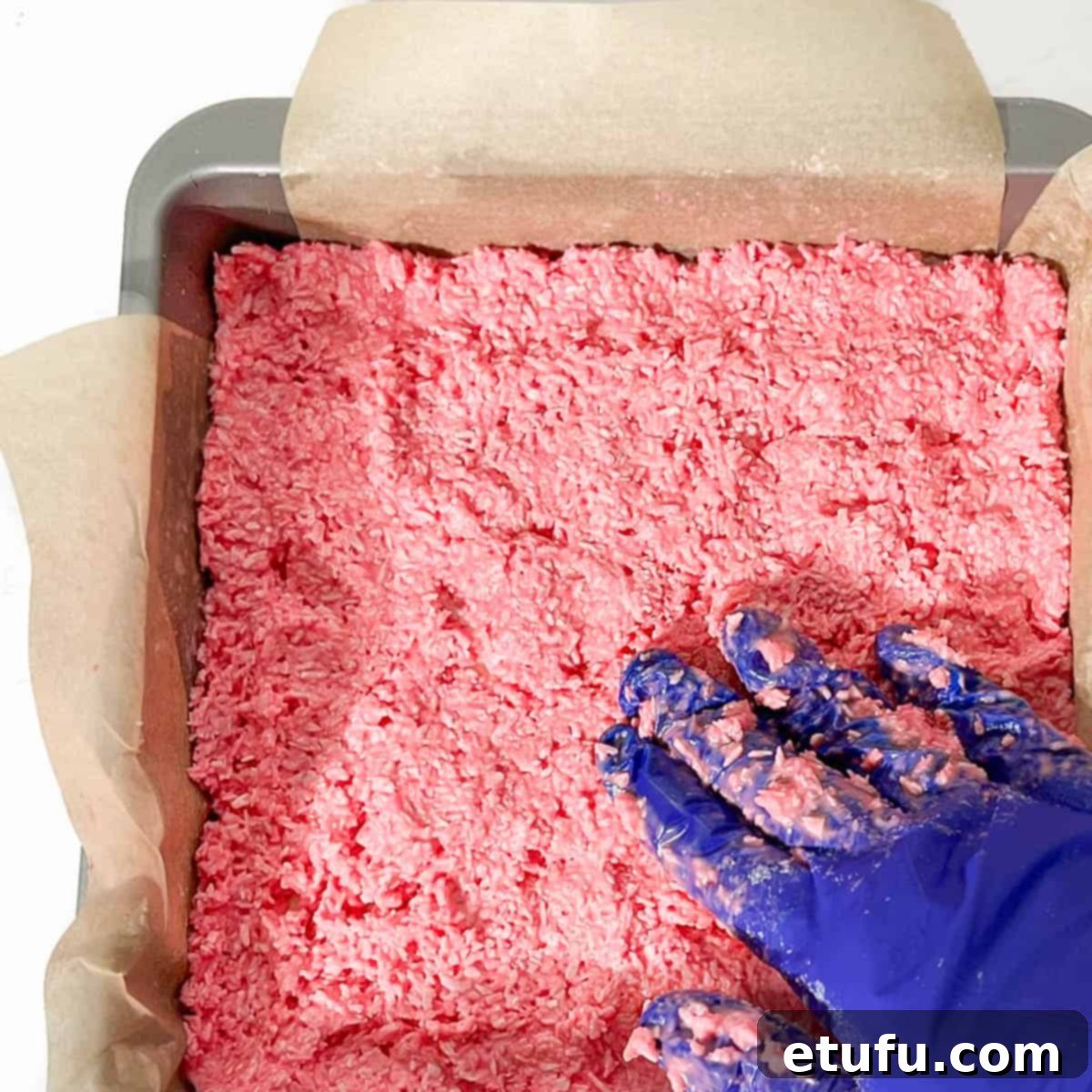 Spreading the pink mixture into the tin.