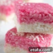 Two pieces of white and pink coconut ice stacked on top of each other.