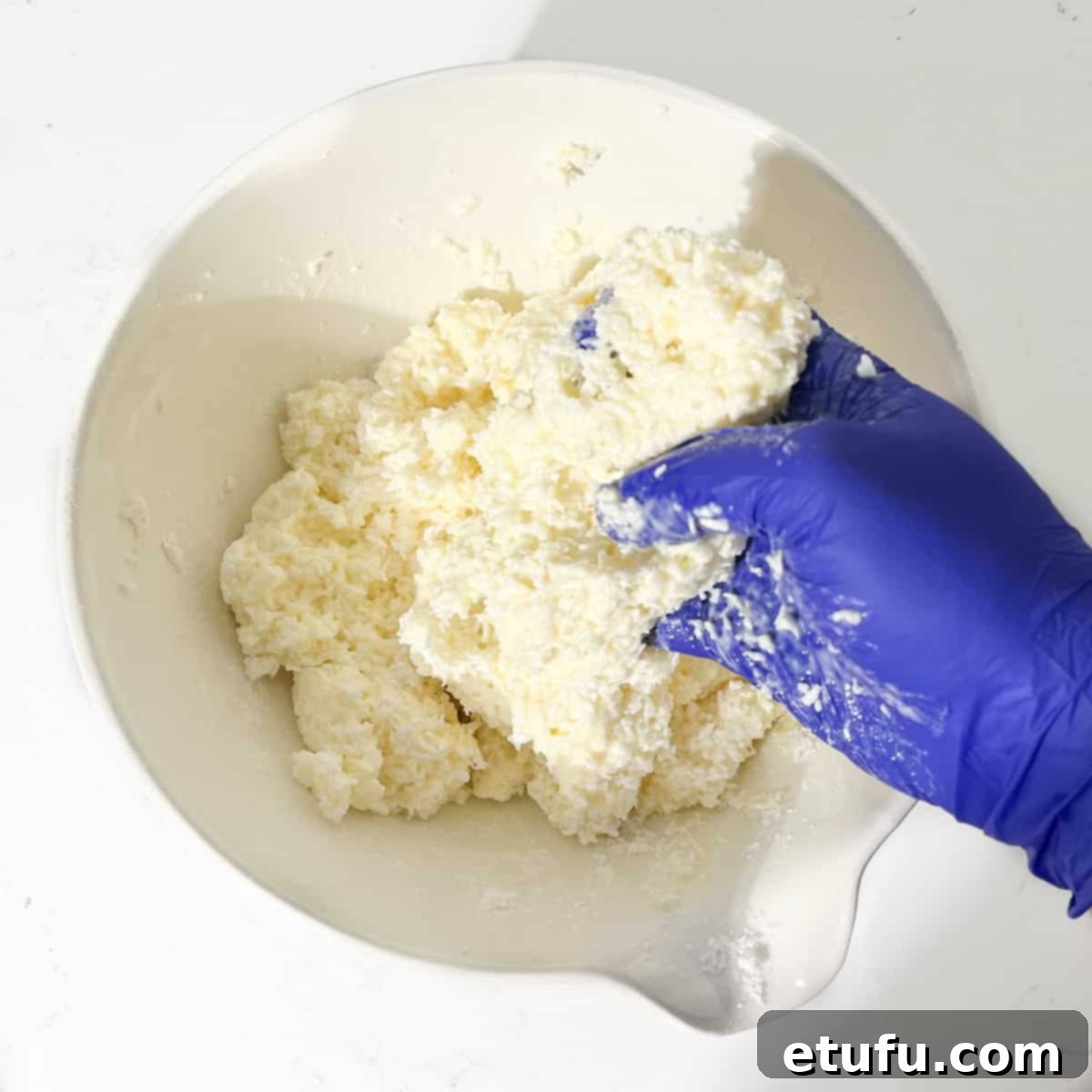 Mixing the coconut ice mixture by hand.