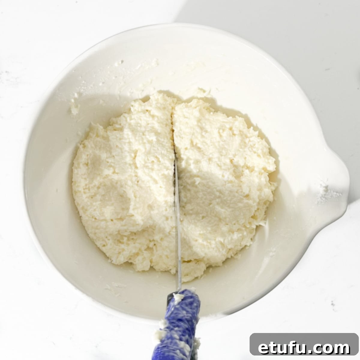 Dividing the coconut ice mixture in half.