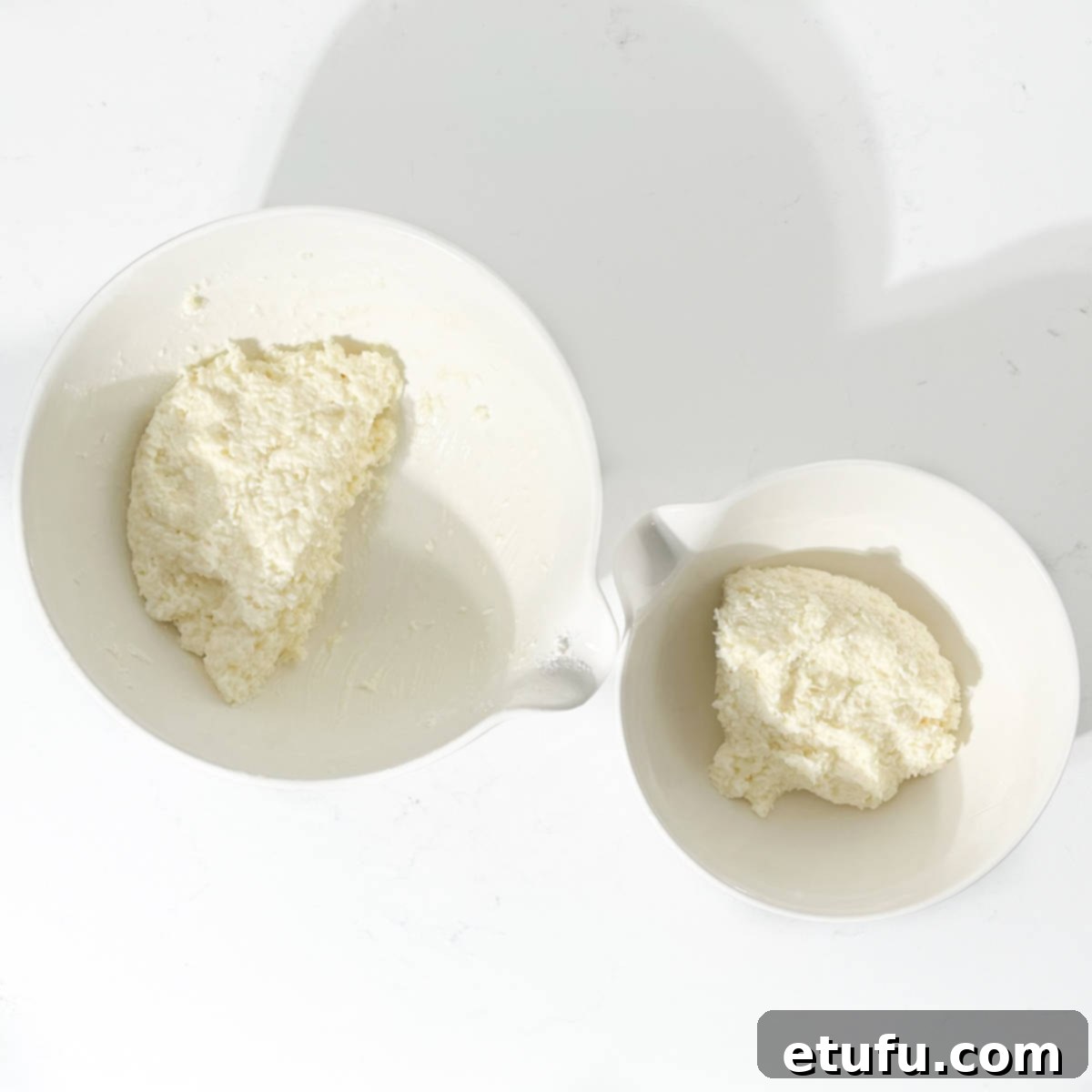 Two bowls with coconut ice mixture.