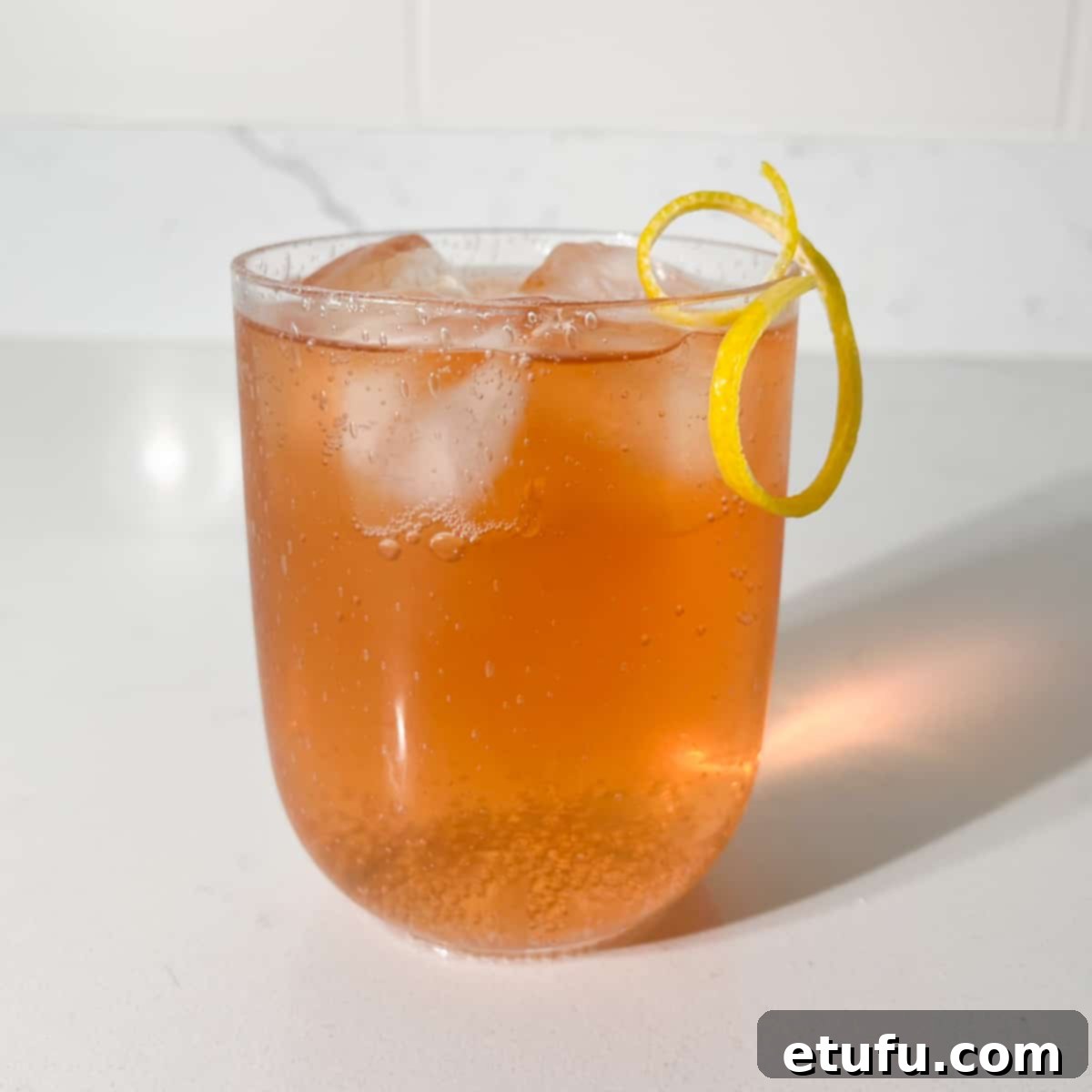 A glass of completed rock shandy with an elegant lemon peel twisty garnish.