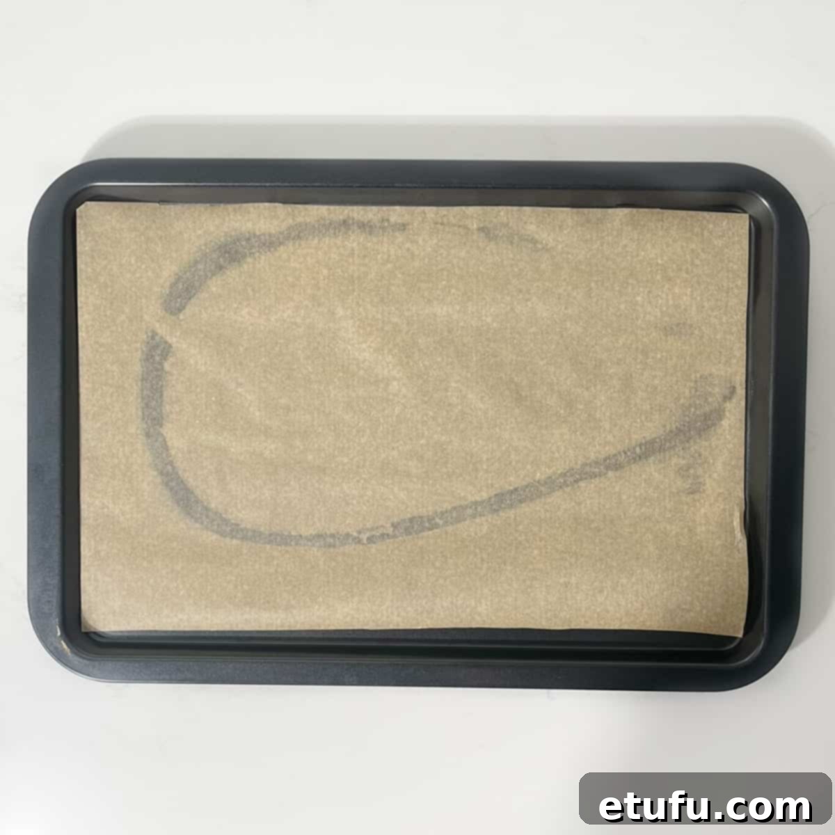 A baking tray meticulously lined with parchment paper, lightly oiled to prevent sticking and ensure easy cleanup for the stuffed courgettes.