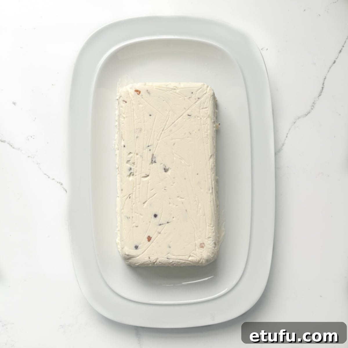 The beautifully unmolded Cassata ice cream, freshly turned out onto a pristine white serving plate, revealing its vibrant interior.