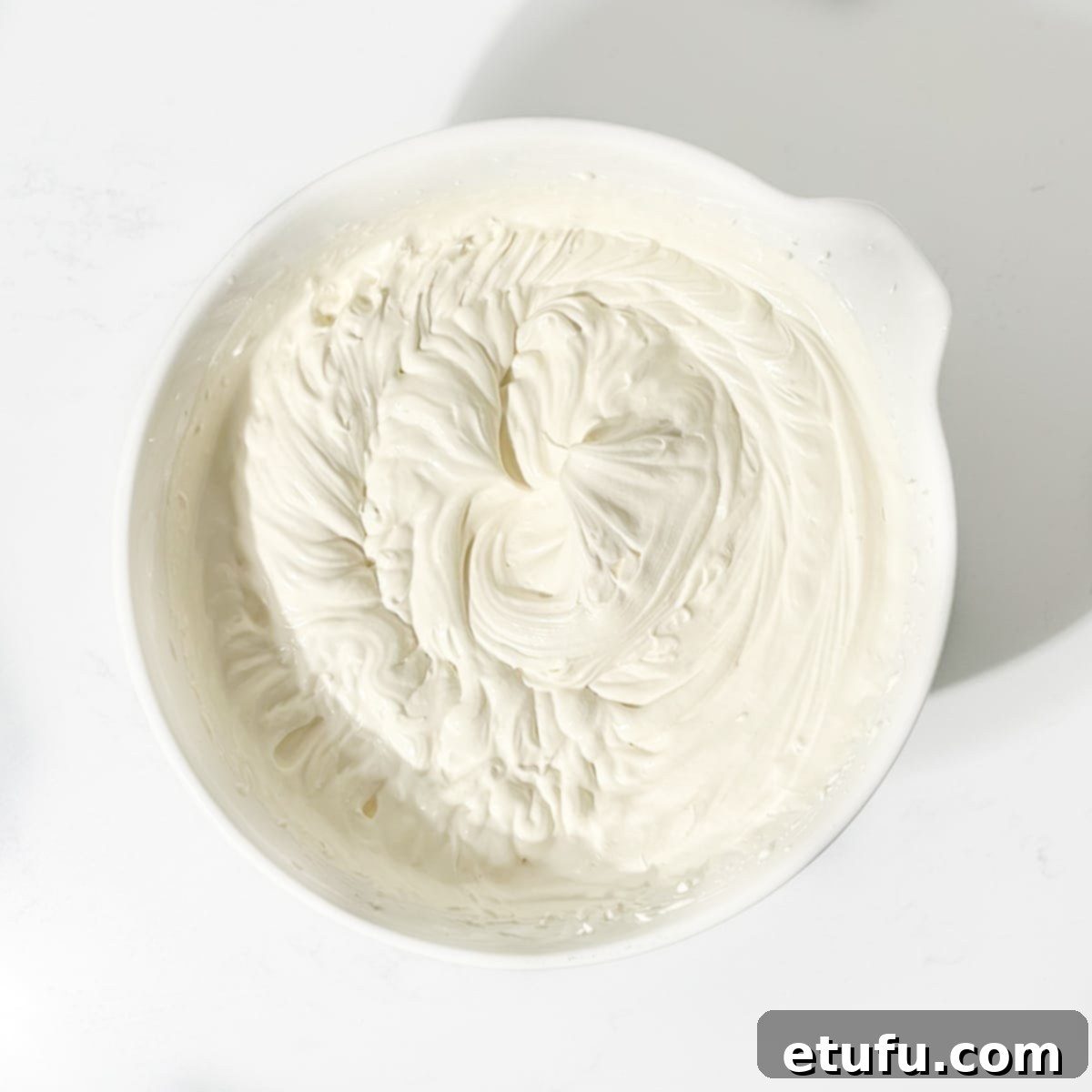 A bowl showcasing the perfectly whipped mixture of cream and condensed milk, ready for the next step of the no-churn Cassata preparation.