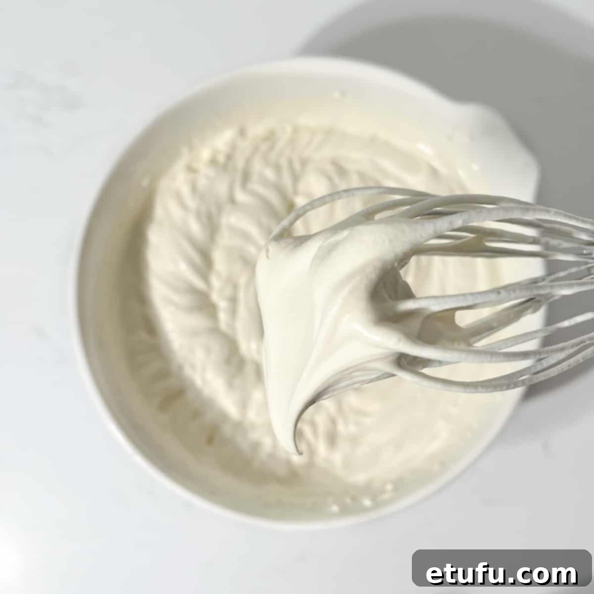 Showing the soft peak consistency of the ice cream mixture, indicating it's ready for the mix-ins.