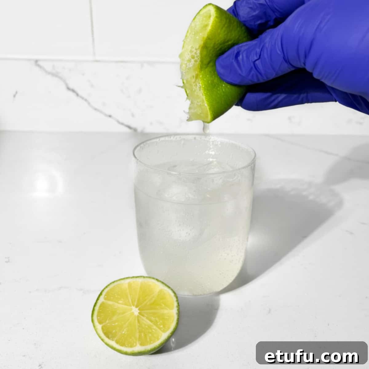 Squeezing lime into a glass.