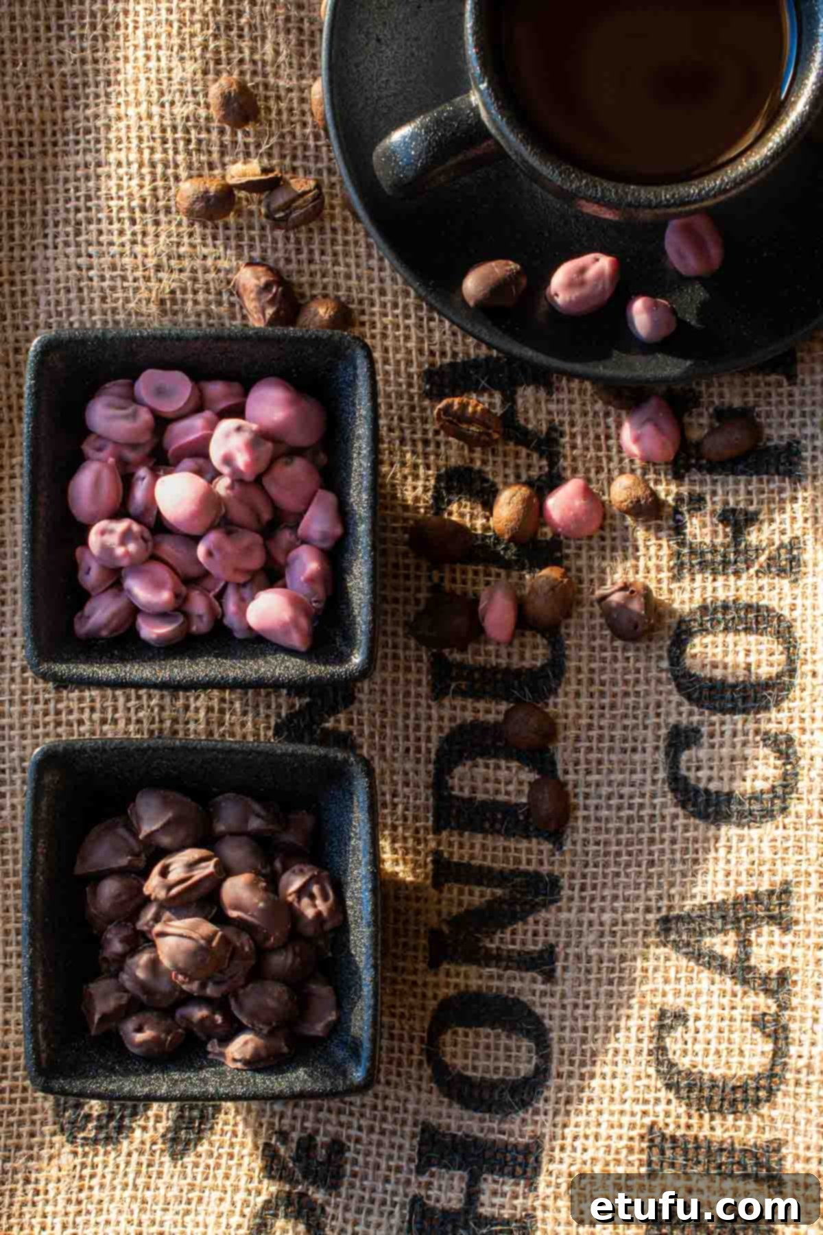 Exquisite ruby and dark chocolate-covered coffee beans artfully arranged in elegant black pots, set against a rustic coffee sack background, highlighting their rich textures and vibrant colors.