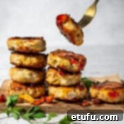 Two piles of chicken rissoles on a wooden board.