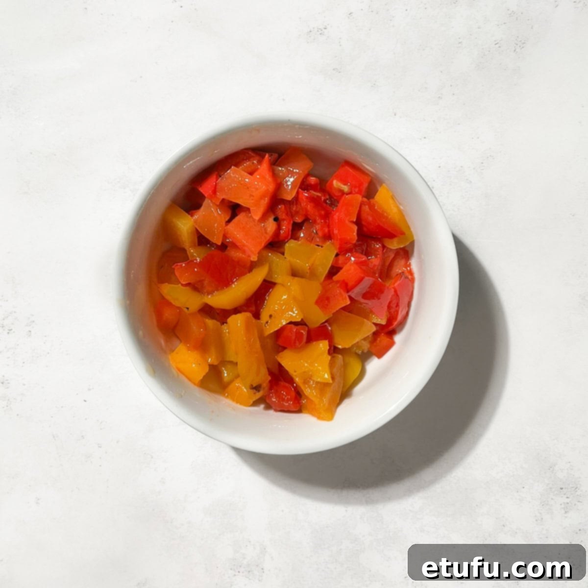 Chopped, roasted pepper in a small white bowl.