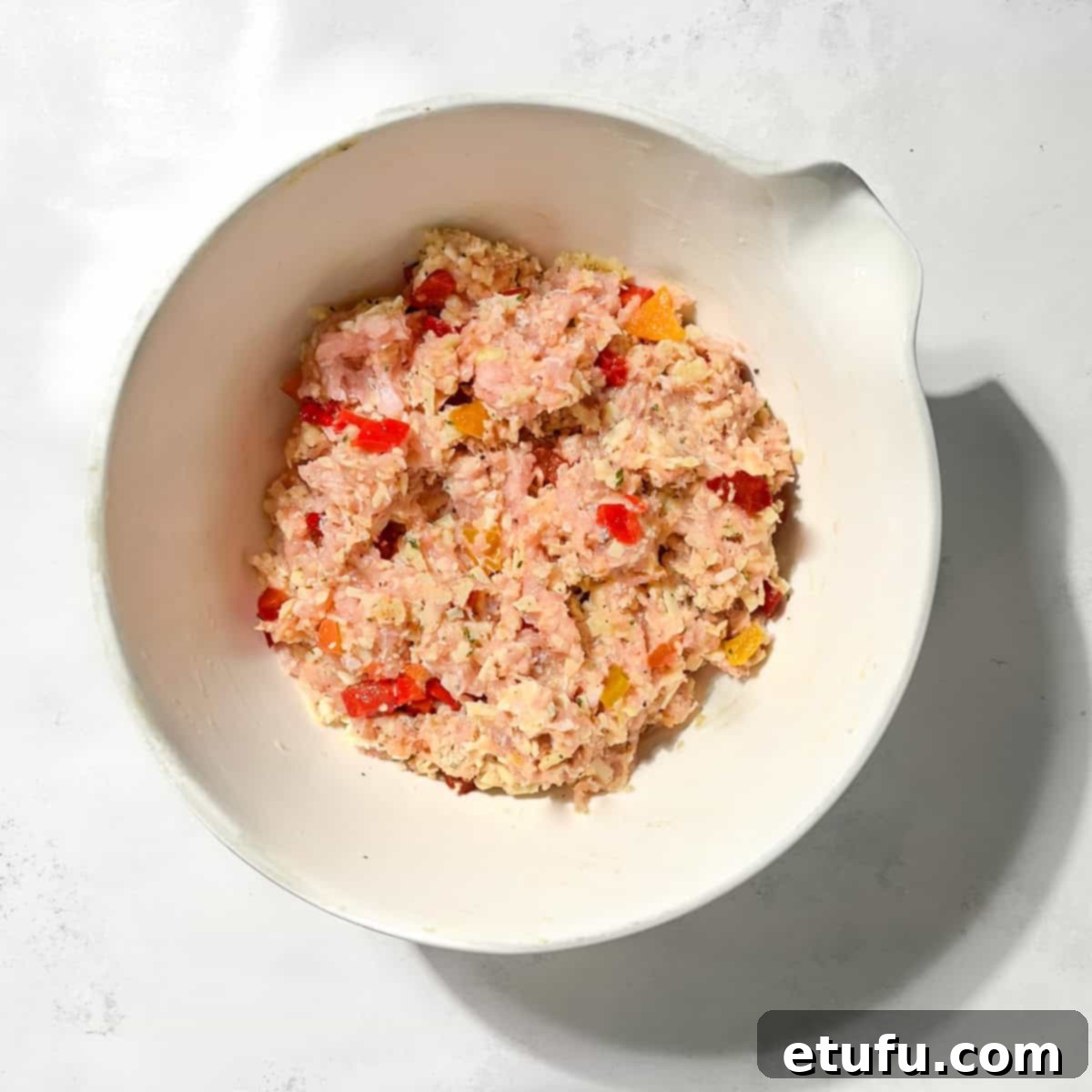 Chicken rissoles mixture in a large white bowl.
