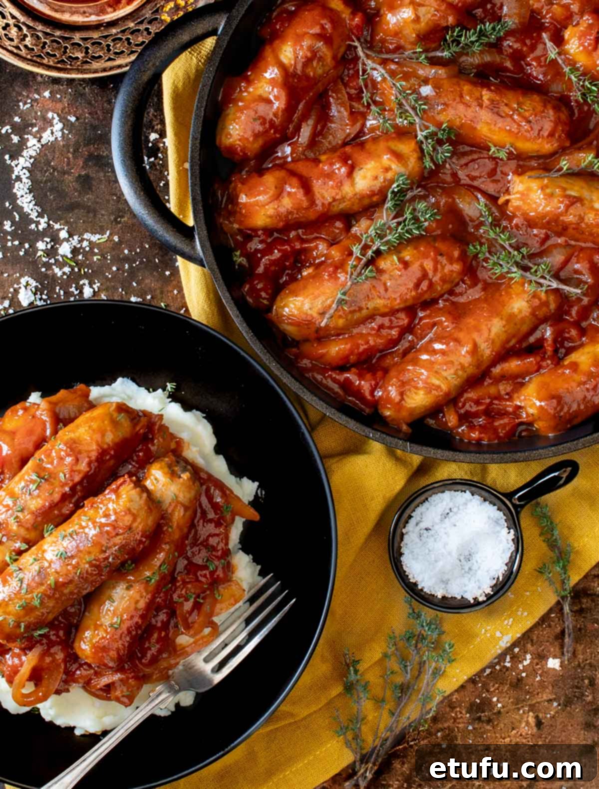 Ultimate Devilled Sausages 2 Devilled sausages in a pan with a bowl of devilled sausages and mash.