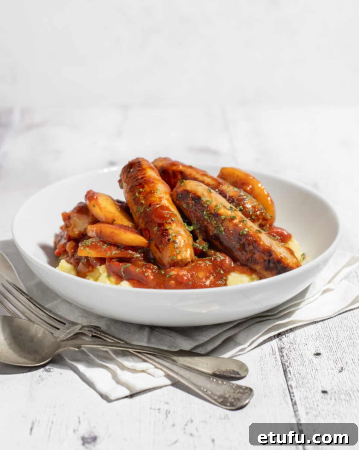 Ultimate Devilled Sausages 4 Devilled sausages on a bed of mashed potato.