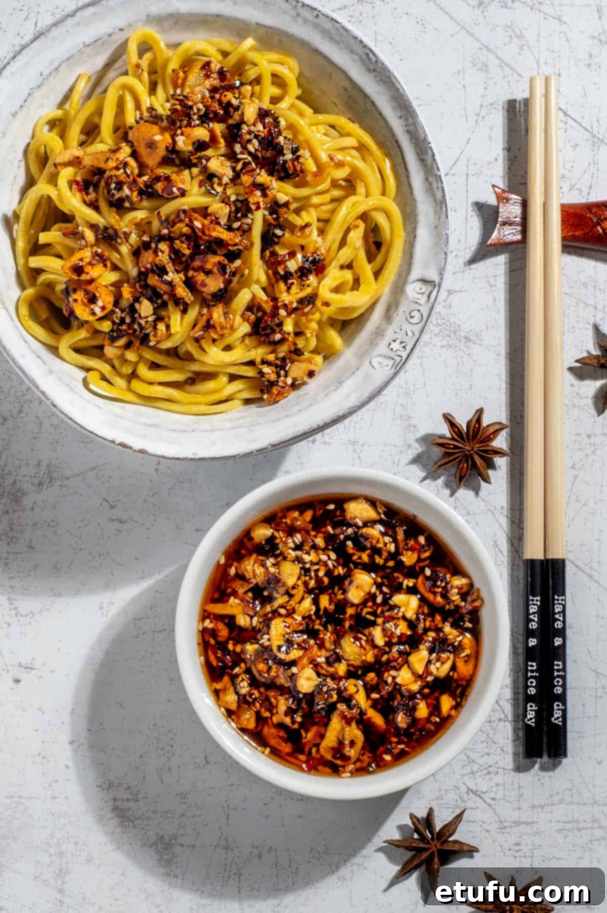 A bowl of crispy chilli oil alongside a bowl of egg noodles, showcasing its versatility and appeal.