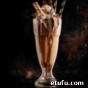 Nutella Milkshake Magic: Only 3 Ingredients 7 Nutella milkshake in a milkshake glass on a dark background.