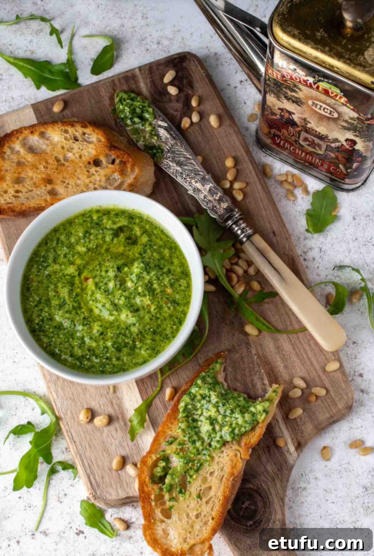 Rocket pesto in a bowl surrounded by slices of toasted ciabatta.