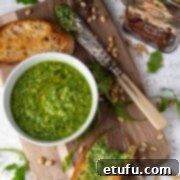 Rocket pesto in a bowl surrounded by slices of toasted ciabatta.