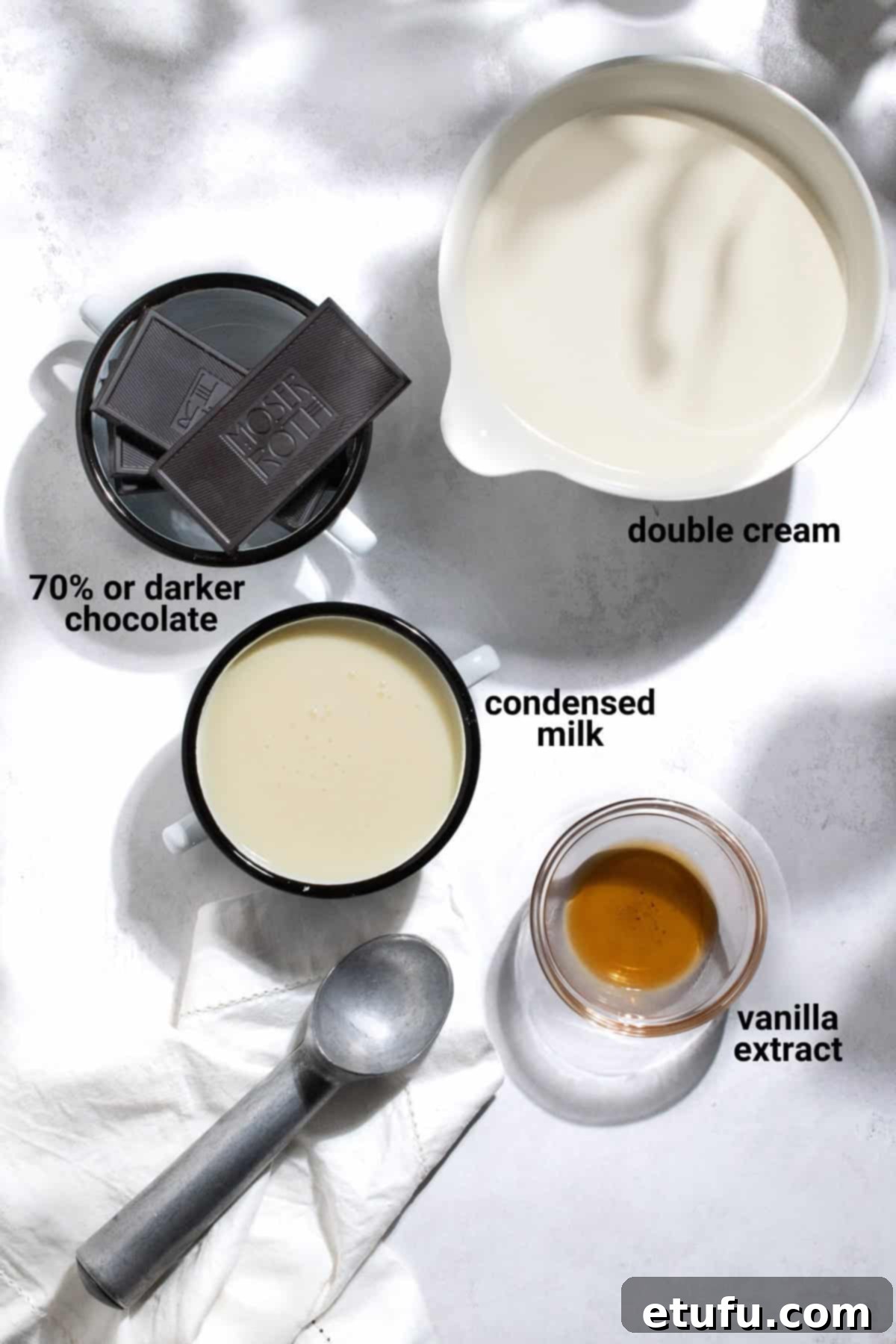 Dark chocolate ice cream ingredients laid out on a white surface.