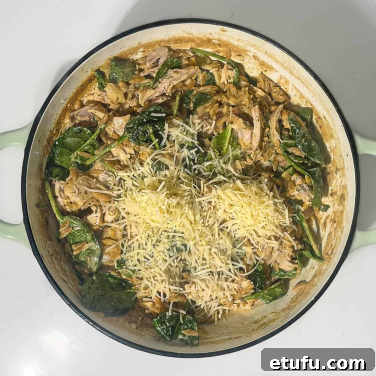 Adding parmesan and lemon juice to the orzo pasta for the finishing touches.