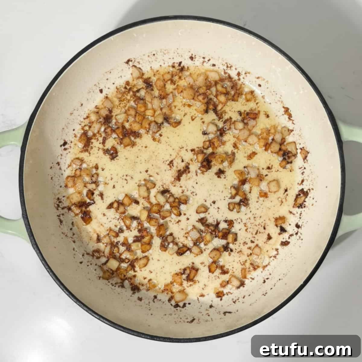 Caramelizing onions in browned butter in a large frying pan.