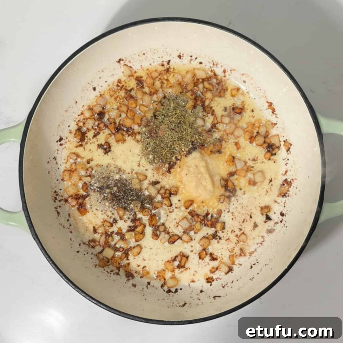 Adding herbs and spices to the caramelized onions.