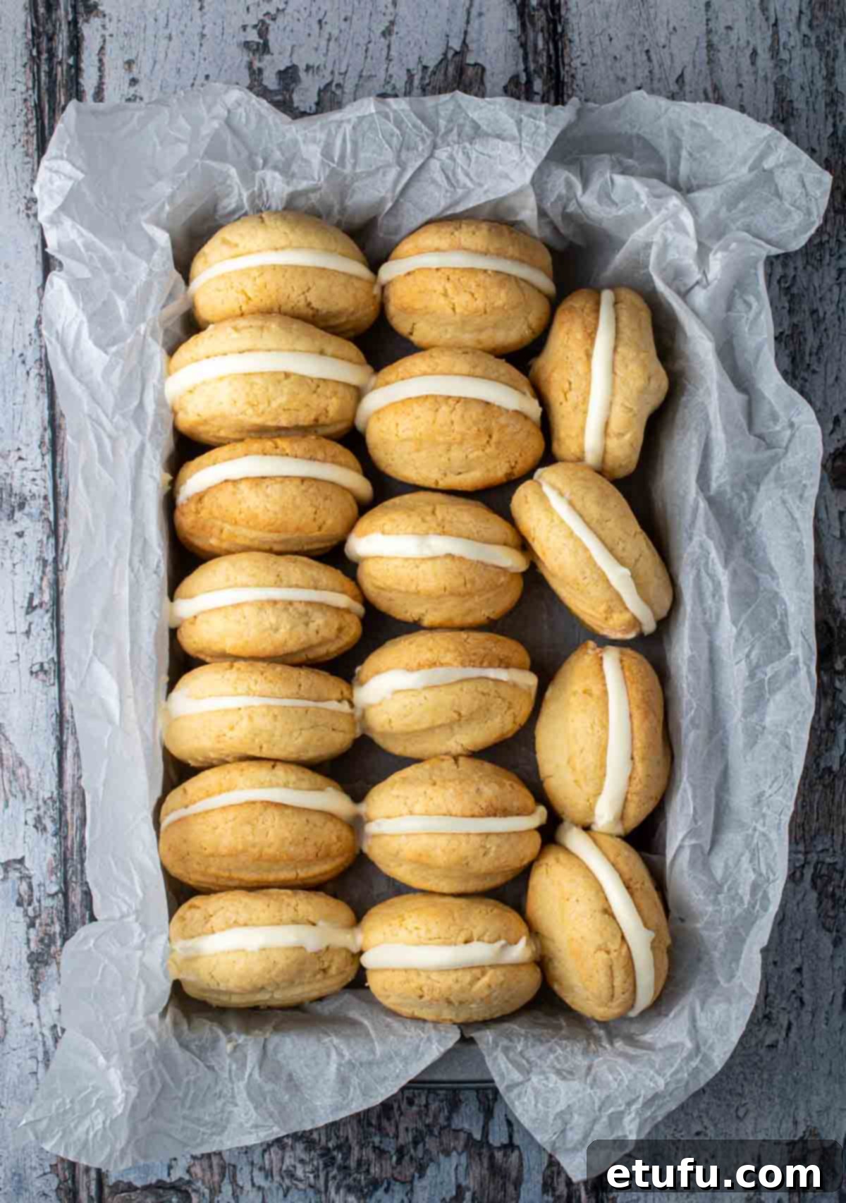 Condensed milk cookies lined up in a baking tray wrapped with baking paper.