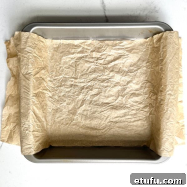 a tin lined with scrounged up and damp baking paper, overhanging on two opposite sides