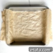 A tin lined with scrounged up and damp baking paper, overhanging on two opposite sides