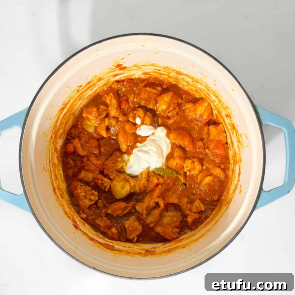 Adding yoghurt to the chicken karahi curry.