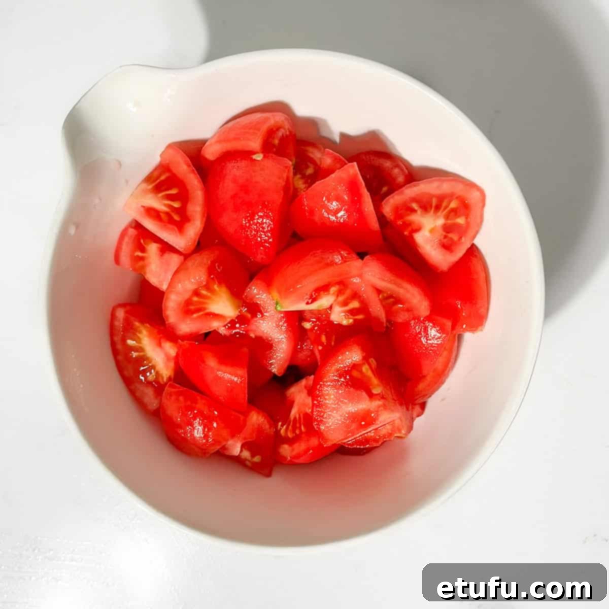 Chopped tomatoes in a small white bowl.